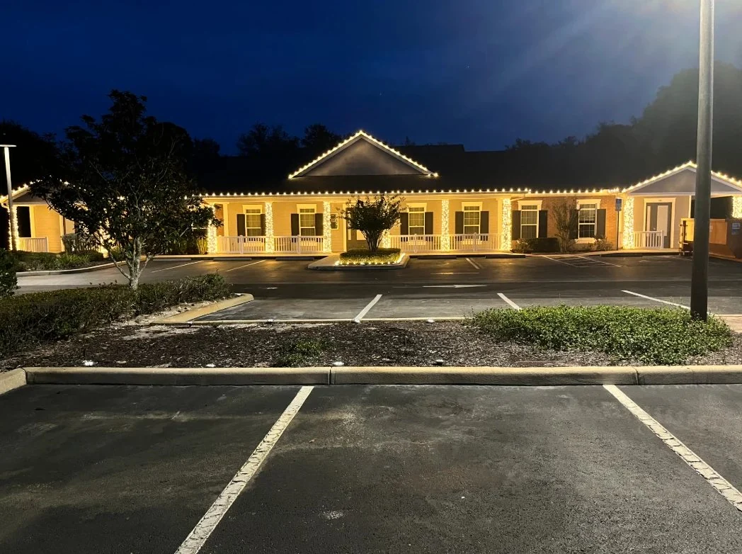 Commercial building illuminated by a complete warm-white C9 holiday light roofline