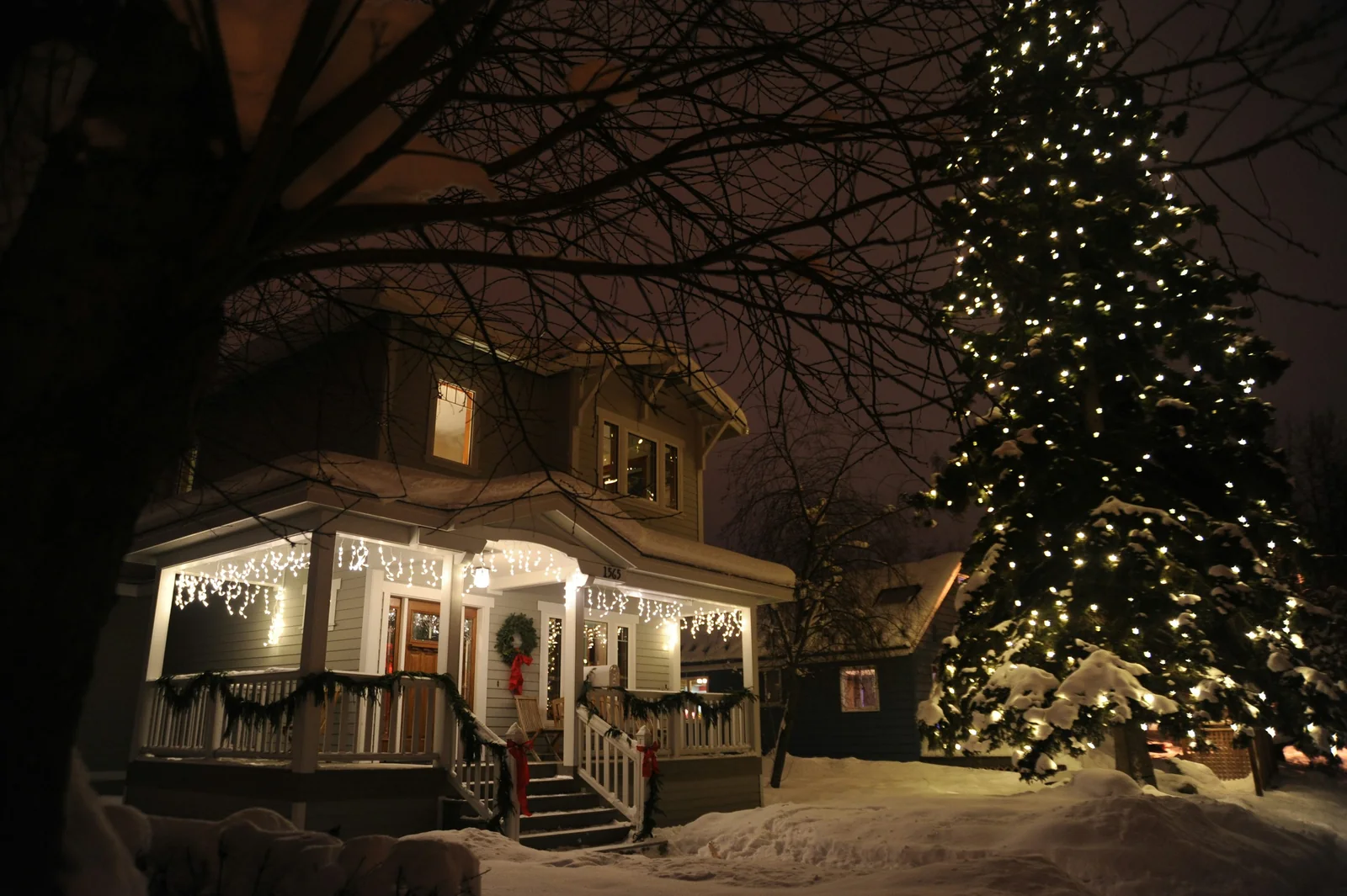 Illustrative home with holiday lights along the porch and roofline